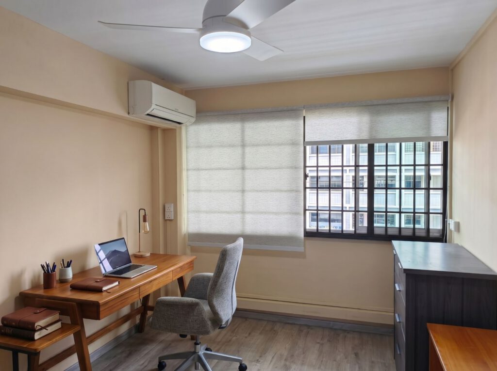Dimout roller blind in a home study room in a Bishan HDB Singapore, soft filtered light reducing screen glare for a comfortable work-from-home and study setup