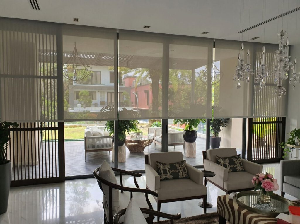 Sunscreen roller blind on large living room windows of a Bukit Timah landed property Singapore, daytime privacy maintained with garden view visible through sunscreen mesh