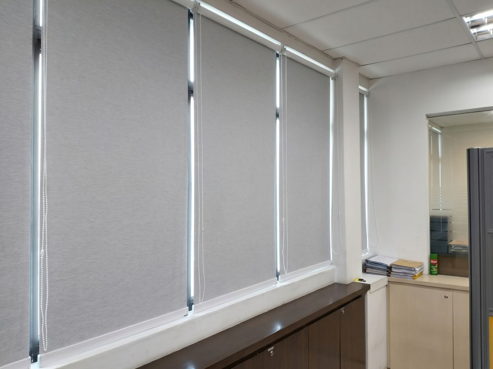 Blackout roller blind fully drawn in a corporate office meeting room in Tanjong Pagar Singapore CBD, complete light blockage for projector presentations