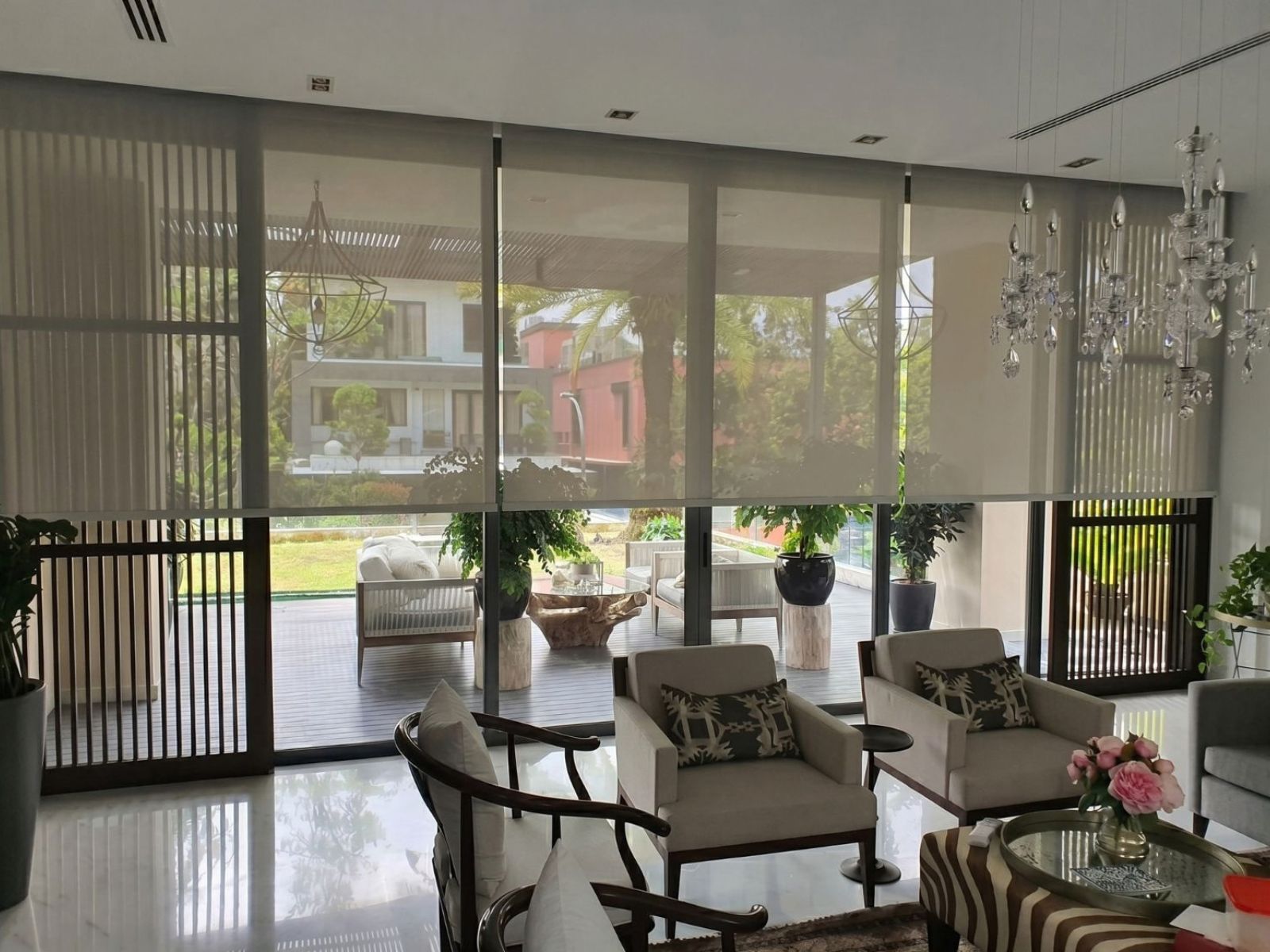 Sunscreen roller blind on large living room windows of a Bukit Timah landed property Singapore, daytime privacy maintained with garden view visible through sunscreen mesh