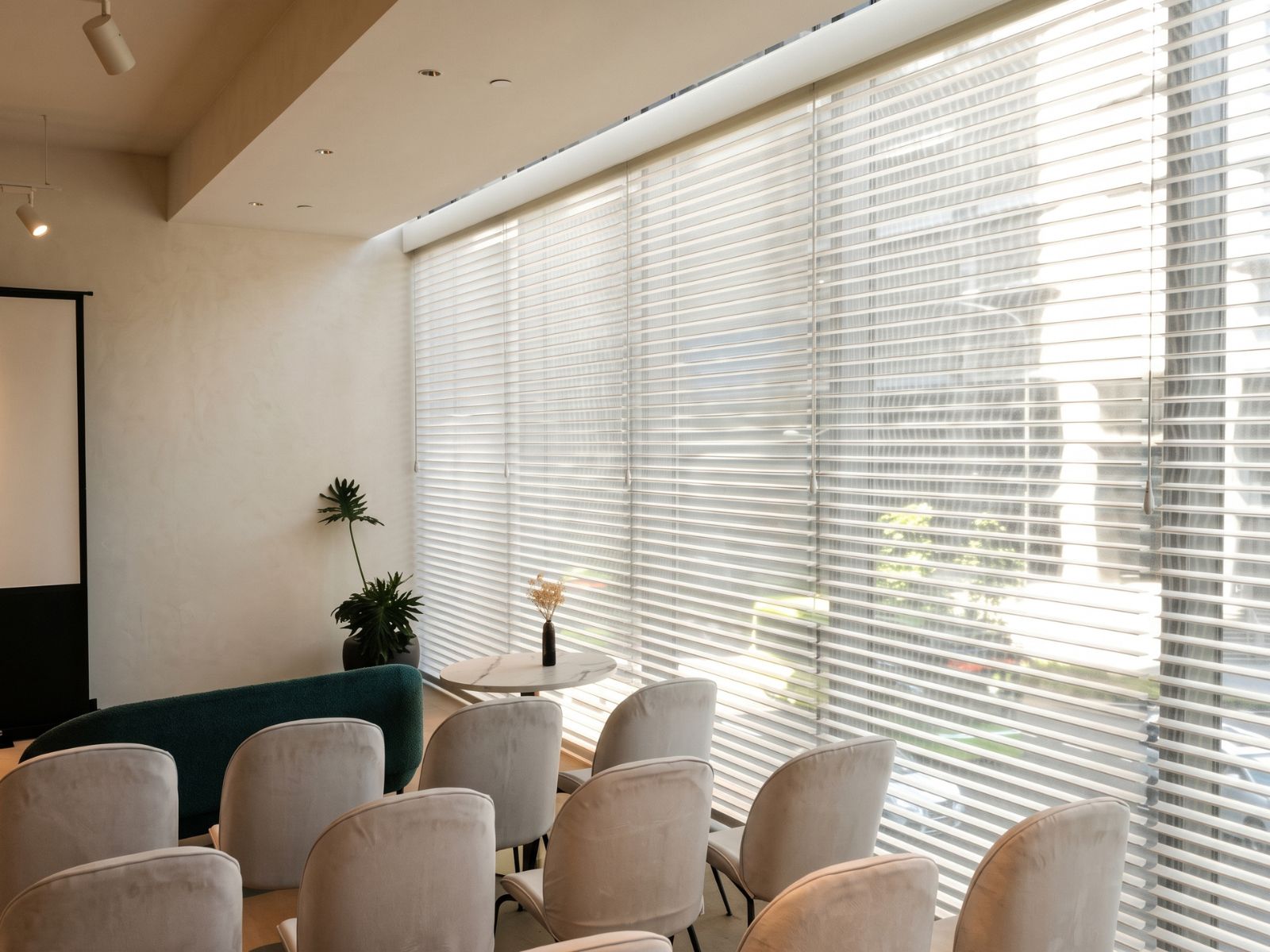 VB Blind white Trishade Shangri-La blinds across large commercial windows, filtering daylight into a modern seating area.
